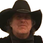Man wearing a large black cowboy hat and dark clothing.