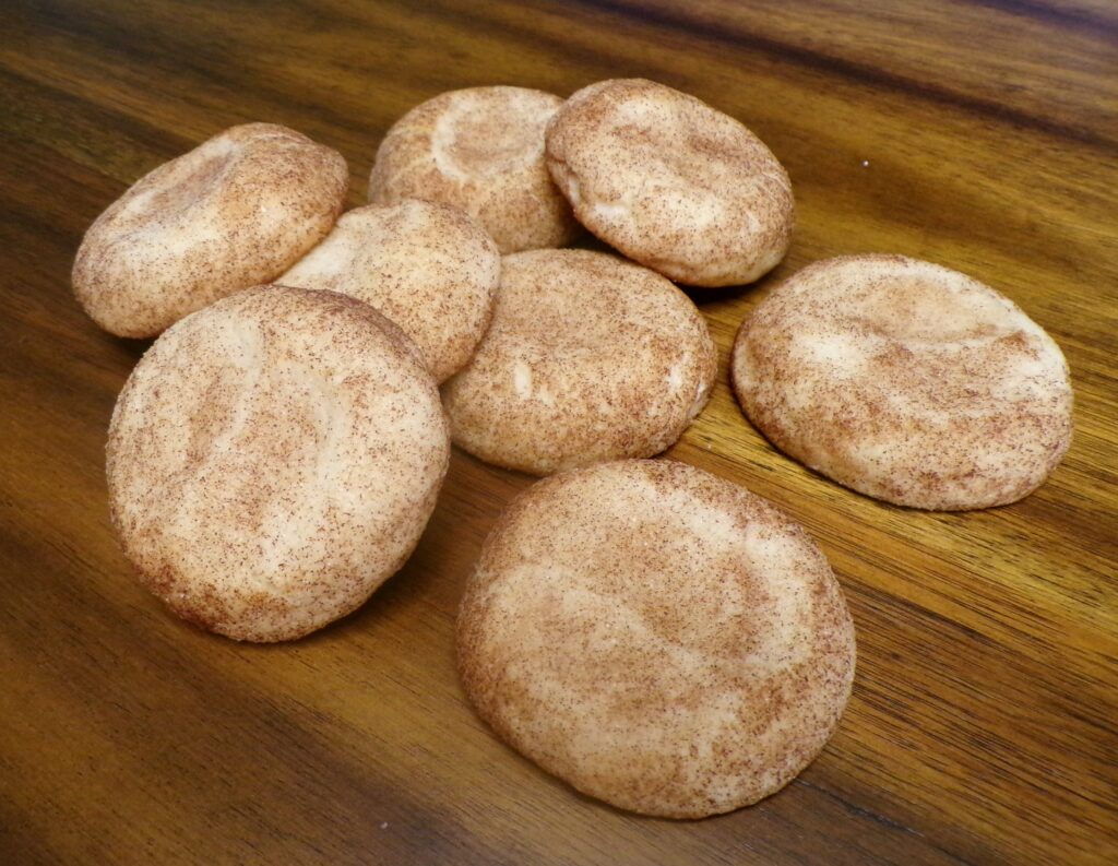 Freshly baked round pita breads cooling on a wooden surface.